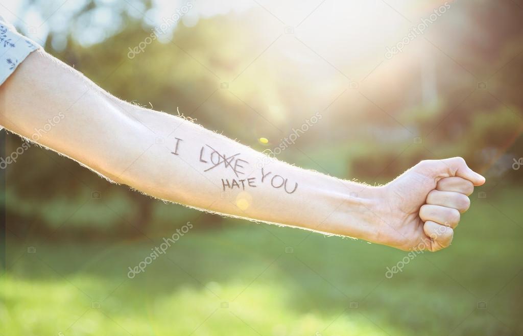 Male arm with text -I hate you- written in skin