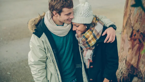 Young couple in love embracing and laughing outdoors — Stock Photo, Image