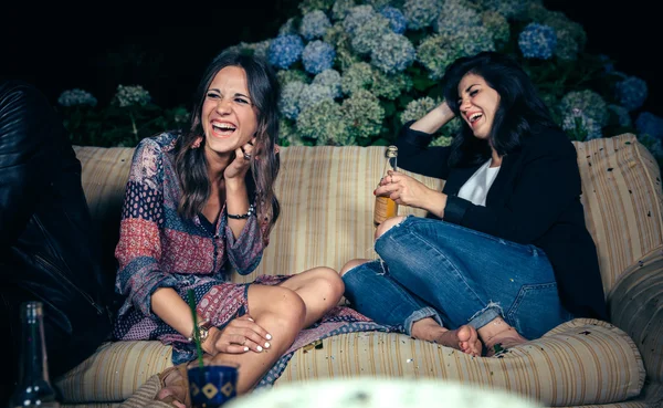 Счастливые женщины-друзья смеются и пьют на вечеринке — стоковое фото