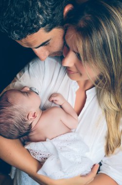 Kucaklayan ve koyu arka plan üzerinde yeni doğan görünümlü mutlu çift