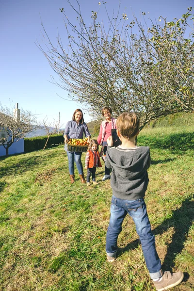Jongen nemen foto familie met appels in de mand — Stockfoto