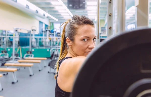 筋肉トレーニングのバーベルを持ち上げ後休んでいる女性 — ストック写真