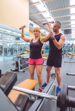 Adam Koç eğitim dumbbells kadına yardım