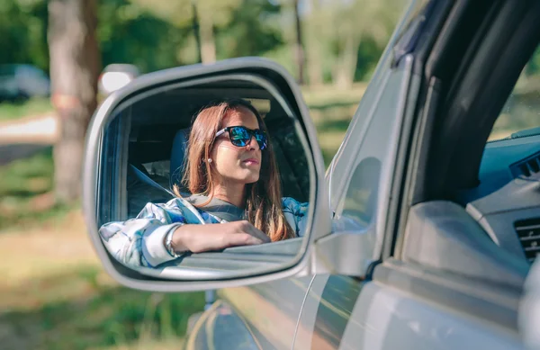 Reflexão no espelho de visão lateral da mulher dirigindo carro — Fotografia de Stock