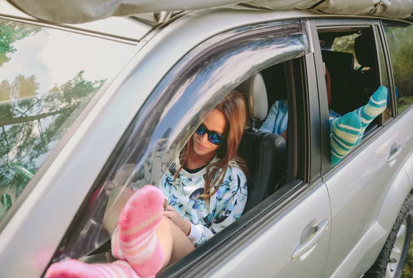 Frau ruht mit den Beinen über offenem Fenster Auto — Stockfoto