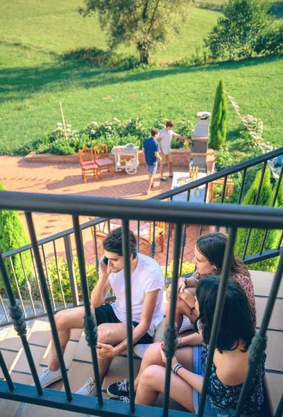 Young man calling by phone sitting on home stairs — Stock Photo, Image