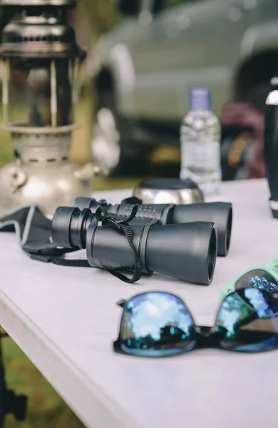 Close up of binoculars over camping table — Stock Photo, Image