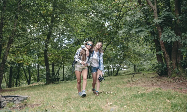 Mulheres amigas rindo enquanto caminham na floresta — Fotografia de Stock