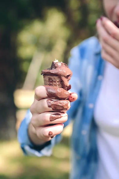 Young woman eating chocolate ice cream in forest — Stock Image Young woman eating chocolate ice cream in forest Stock Photo