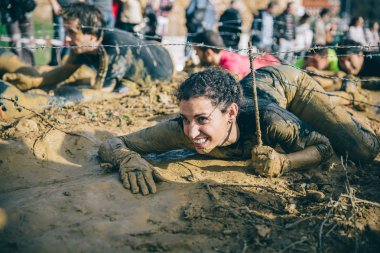 Dikenli tel aşırı engel ırkının testindeki altında sürünerek runner