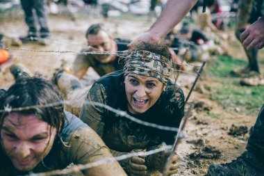 Dikenli tel aşırı engel ırkının testindeki altında sürünerek runner