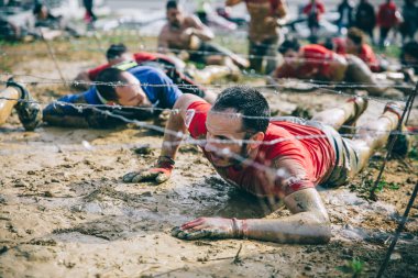 Dikenli tel aşırı engel ırkının testindeki altında sürünerek runner