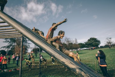 Runners going down structure in a test of extreme obstacle race