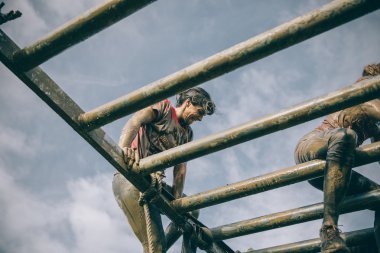 Runner climbing structure in a test of extreme obstacle race