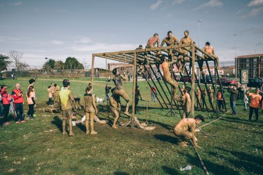 Runners climbing structure in a test of extreme obstacle race