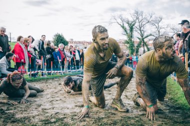 Happy runner after to cross electrified mesh in a test of extreme obstacle race