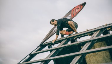Runner going down wall in a test of extreme obstacle race
