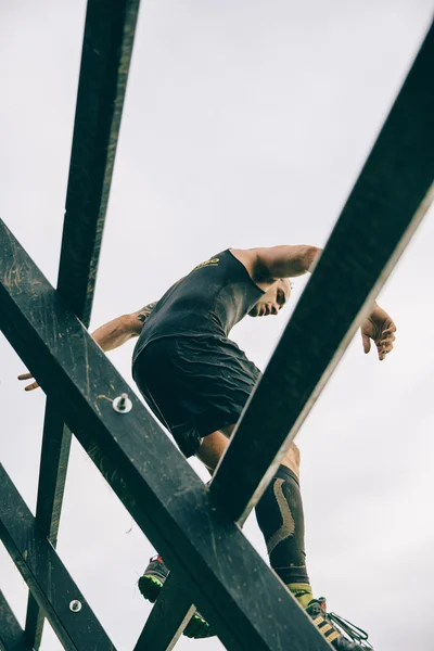 Runner going down wall in a test of extreme obstacle race — Stockfoto