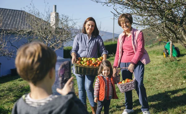 Family with apples in basket posing to photo — Stock Photo, Image