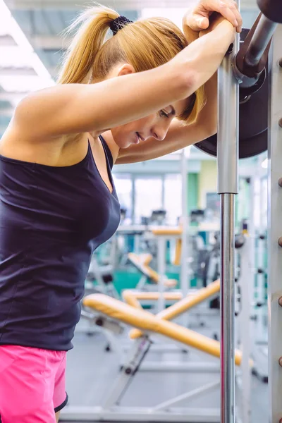 Donna che riposa stanca dopo aver sollevato il bilanciere sull'allenamento muscolare — Foto Stock