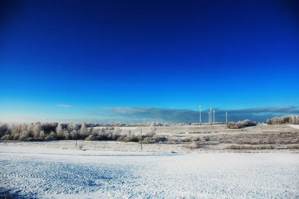 Beautiful cold winter landscape with wind generators on background — Stock Photo, Image