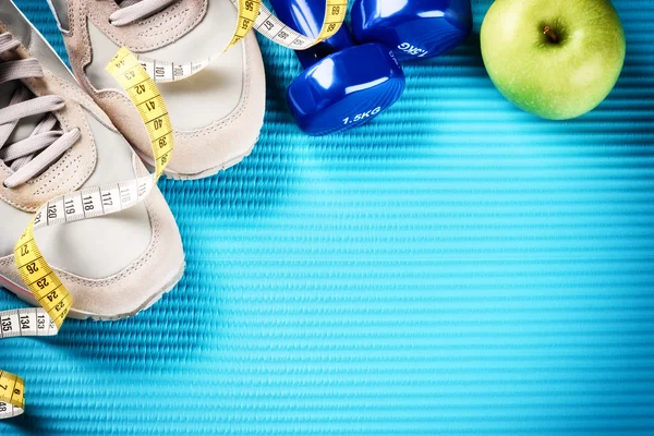 Hanteln, Turnschuhe und grüner Apfel — Stockfoto