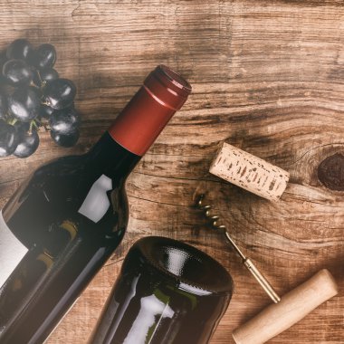 bir şişe kırmızı şarap, üzüm ve mantarlar