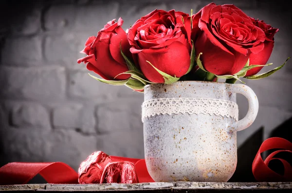Ρύθμιση του Αγίου Βαλεντίνου με μπουκέτο με κόκκινα τριαντάφυλλα — Φωτογραφία Αρχείου