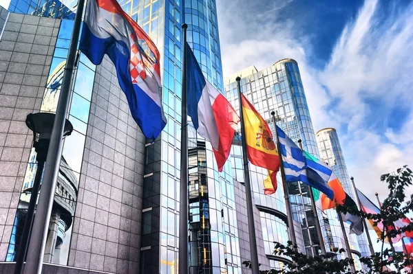 Waiving flags in front of European Parliament building — Stock Photo, Image