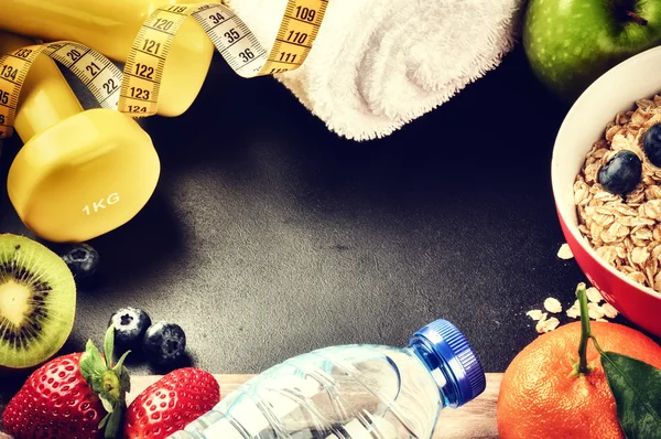 Dumbbells, water bottle and fresh fruits — 图库照片
