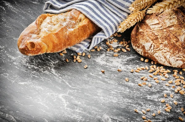 Pão assado e baguete em ambiente rústico — Fotografia de Stock