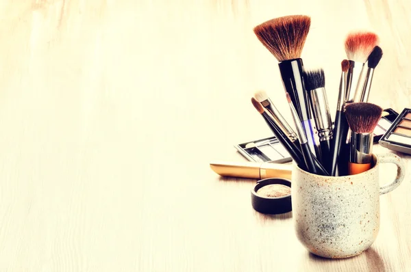 Várias escovas de maquiagem no fundo claro — Fotografia de Stock