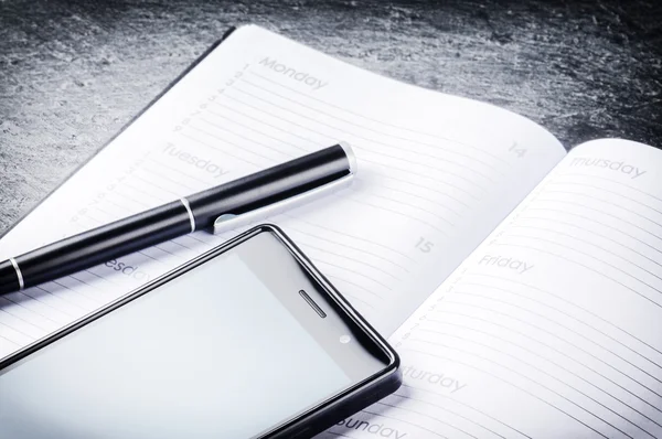 Conceito de negócio com agenda, telefone e caneta — Fotografia de Stock