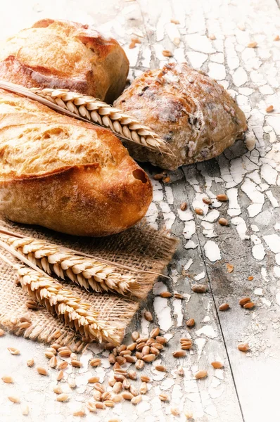 Baguette and buns in rustic setting — Stock Photo, Image