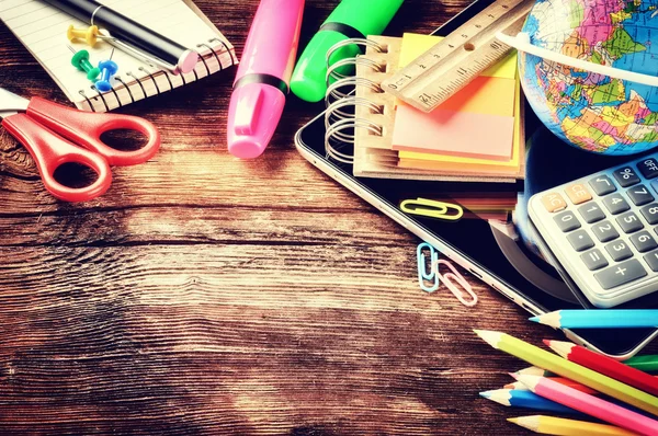 Materiali scolastici colorati su sfondo di legno — Foto Stock