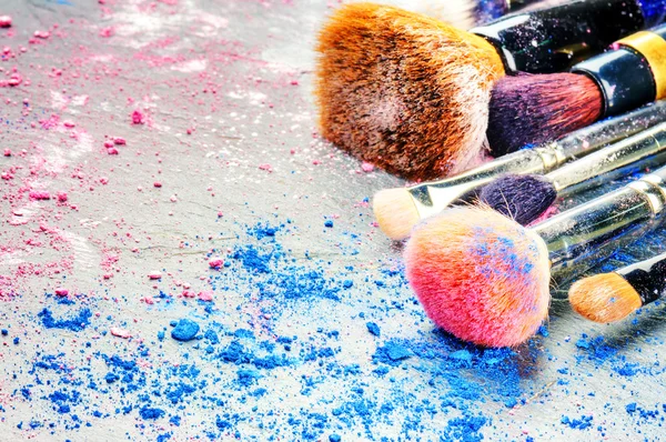 Pinceles de maquillaje y sombra de ojos triturada — Foto de Stock