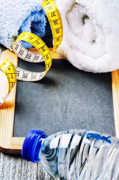 Fitness sfondo con bottiglia d'acqua e asciugamani — Foto Stock