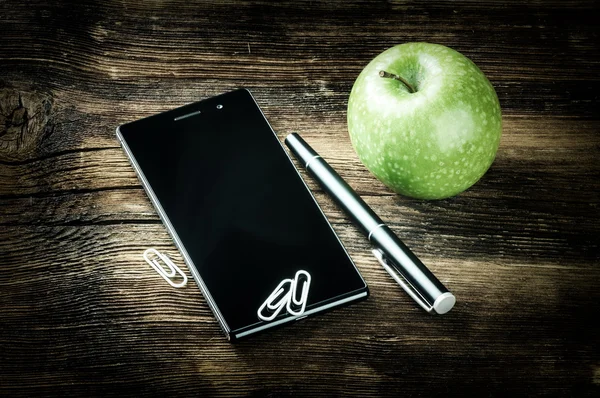 Desktop with smart phone and apple — Stock Photo, Image