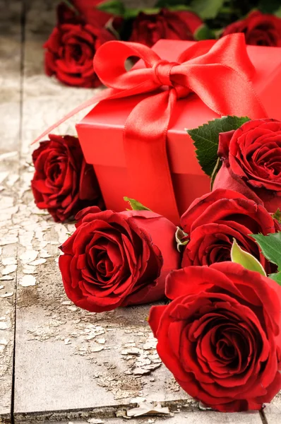 Bouquet of red roses and present — Stock Photo, Image