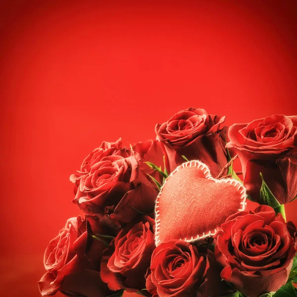 Ramo de rosas rojas con corazón decorativo — Foto de Stock