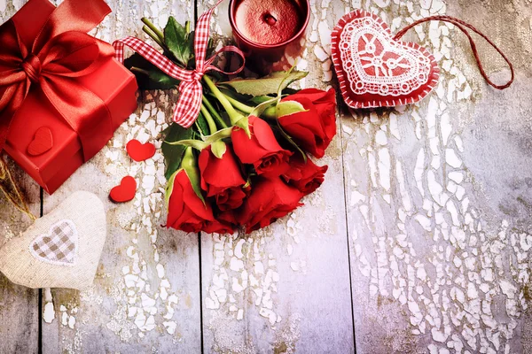 Rote Rosen mit dekorativen Herzen und Geschenken — Stockfoto