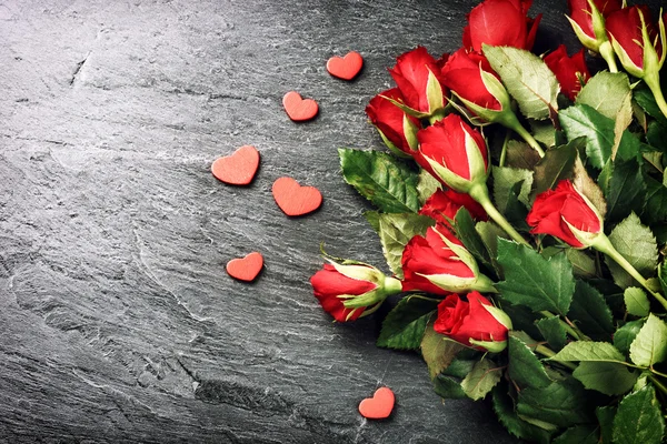 Μπουκέτο με κόκκινα τριαντάφυλλα με διακοσμητικά καρδιές — Φωτογραφία Αρχείου