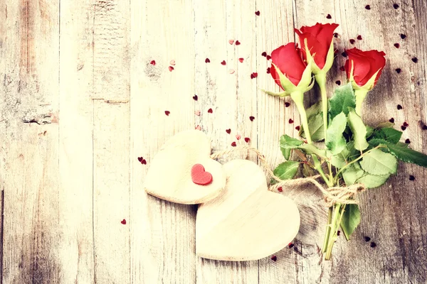 Bukett röda rosor med dekorativa hjärtan — Stockfoto