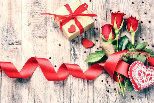 Rosas con corazones decorativos y regalos — Foto de Stock