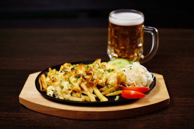 Ahşap masa üzerinde bir tavada et ile kavrulmuş patates