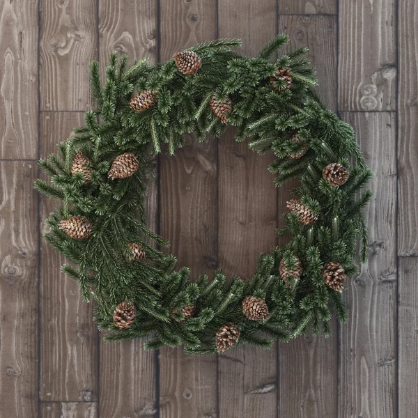 Christmas decorative wreath with cones on wood — Stock Photo, Image