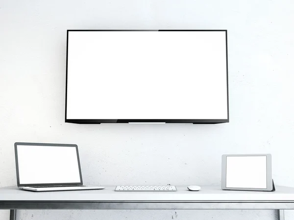 Tabulka s notebookem a velké obrazovce na zdi — Stock fotografie