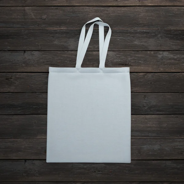 Белая сумка на деревянном столе — стоковое фото