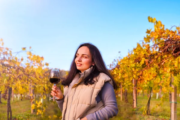 Kvinna med drömskt utseende och ett glas vin på en gård i Italien. Magnifik vingård i bergen i Emmilia Romagna på hösten. — Stockfoto