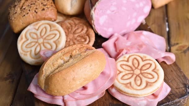 Mortadella et panino sur une table en bois. Pains assortis de différents types, pour des sandwichs italiens traditionnels dans la région d'Emilie-Romagne. — Video